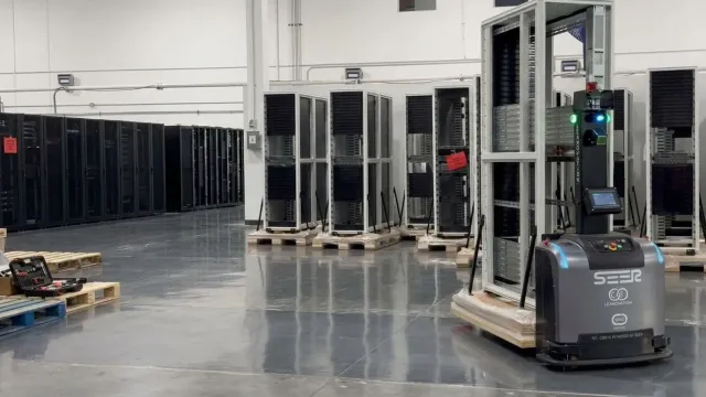 Robot móvil SEER transportando un rack en un almacén.